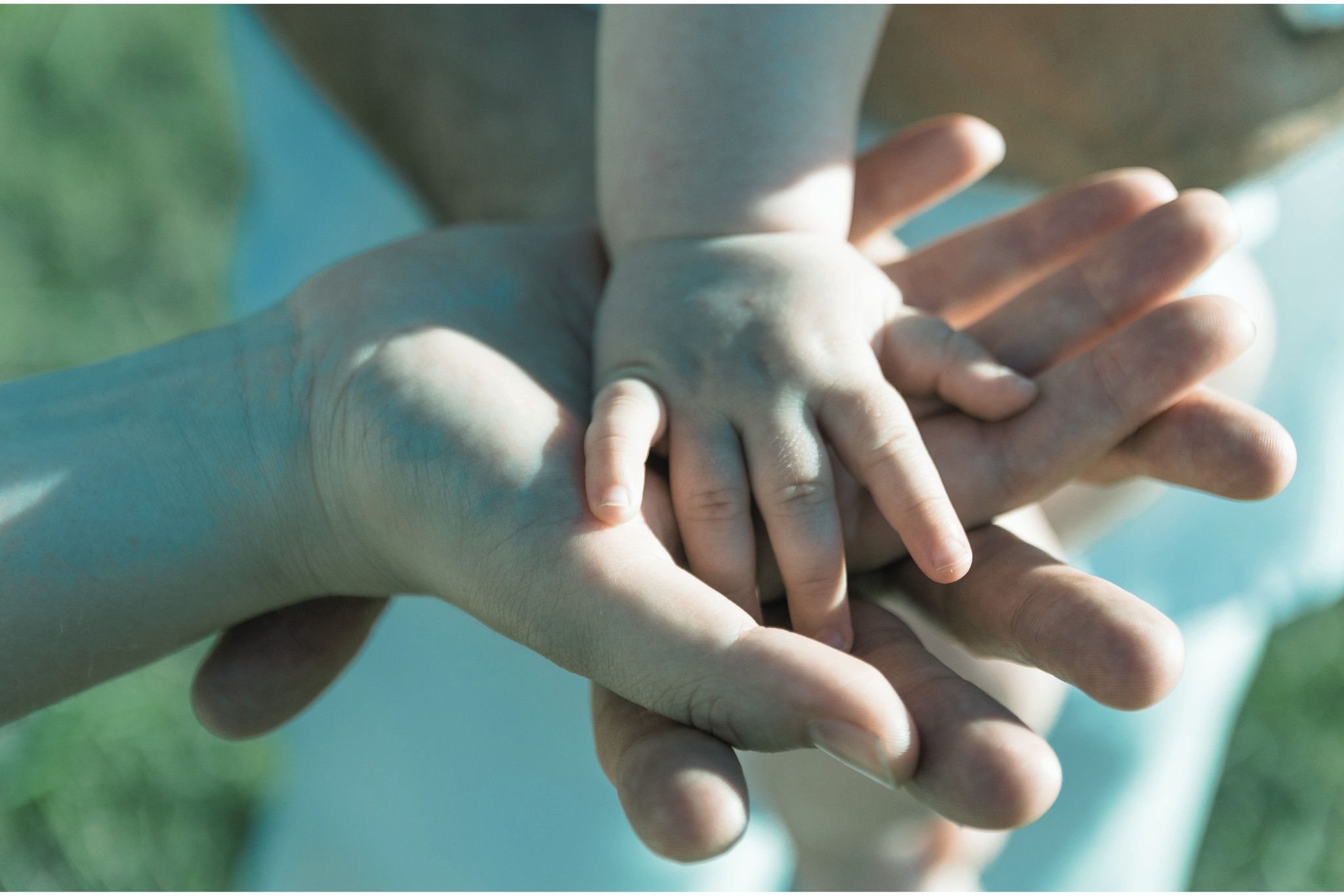 Hands of parents and child one on top of the other