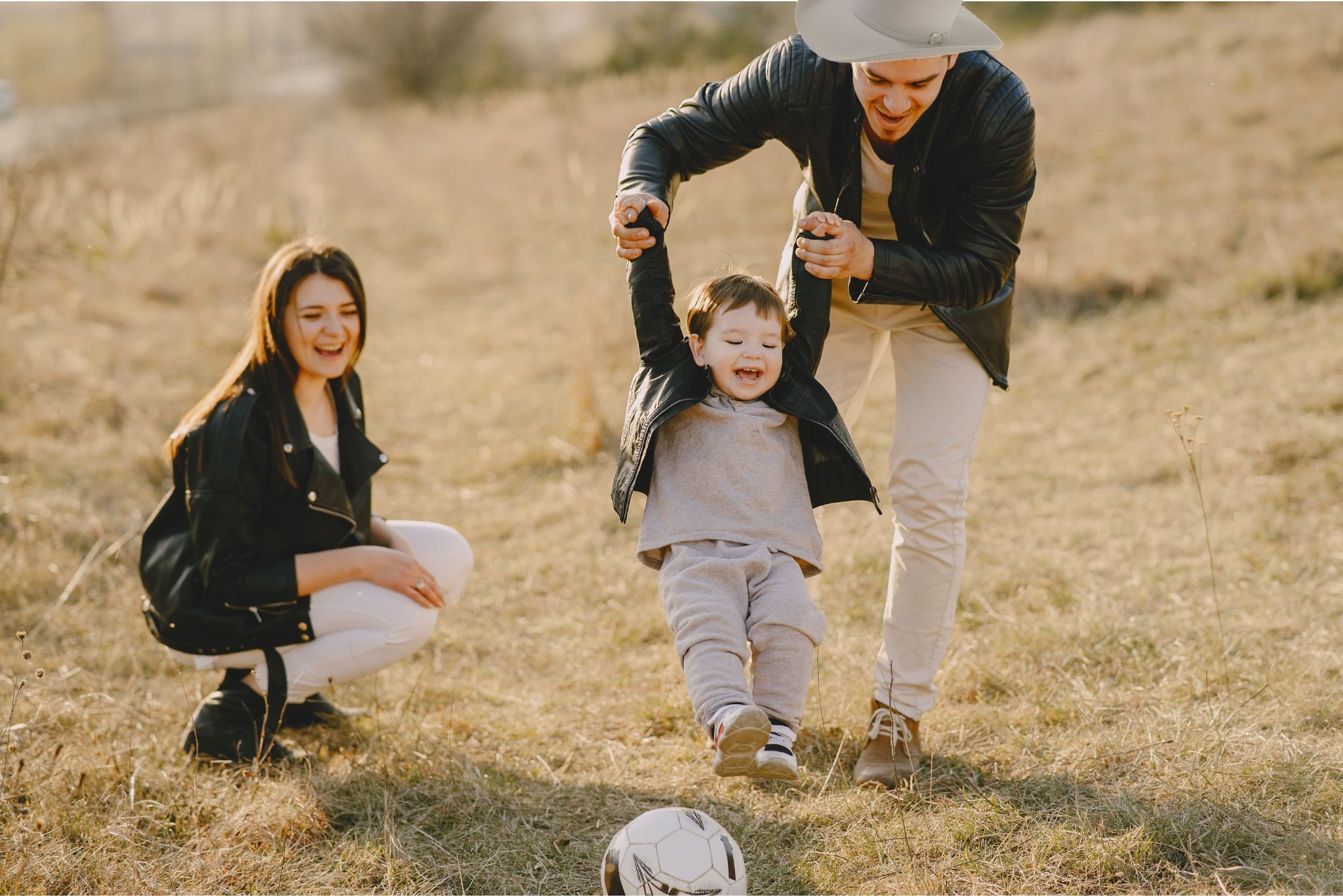 Father, mother and child playing ball outdoor